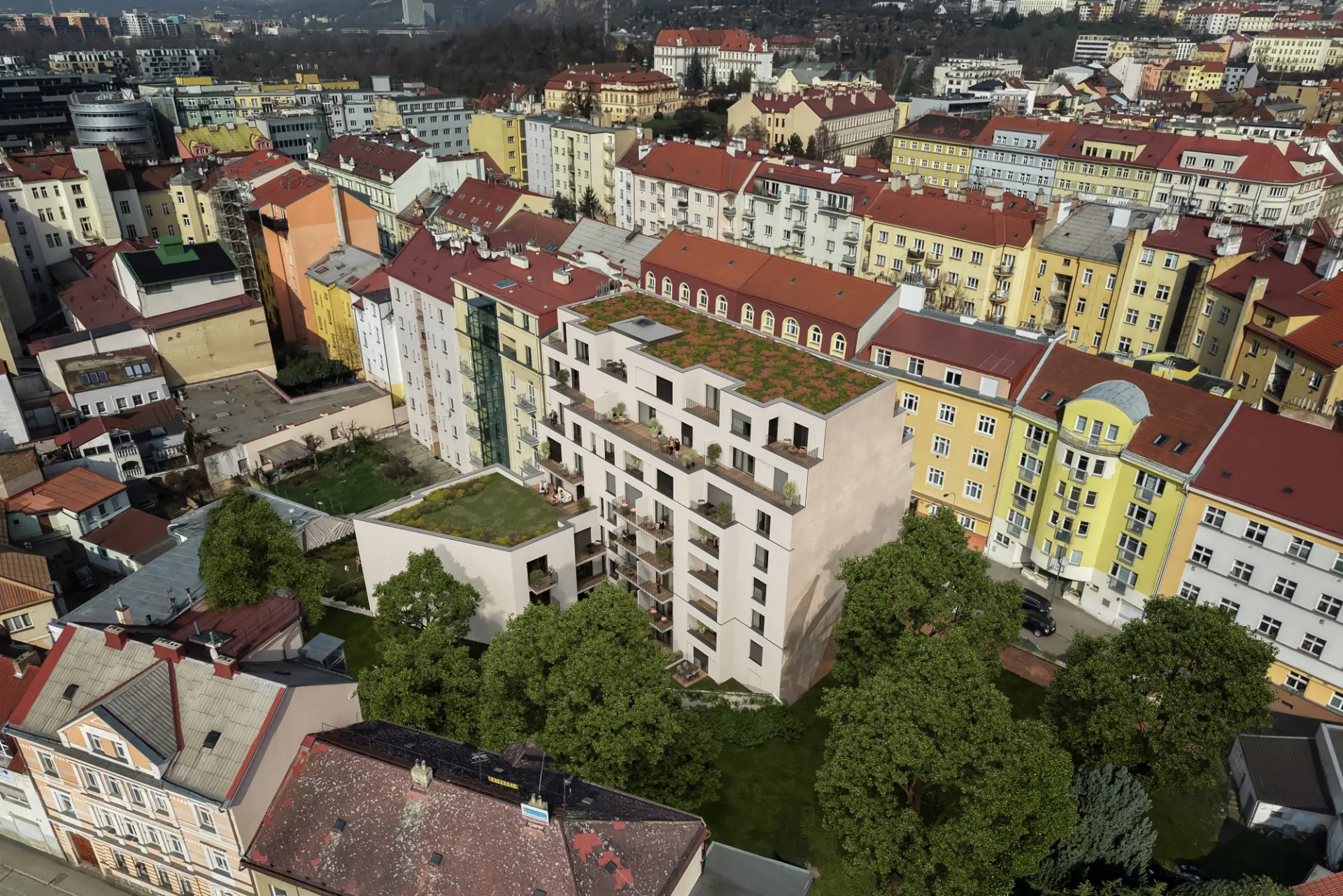 Letecký pohled na budovu obklopenou zelení a starší zástavbou Libně